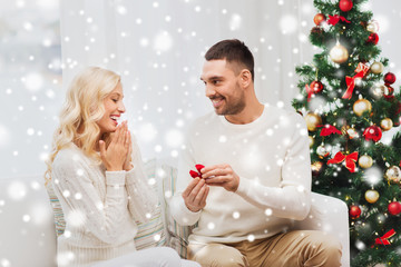 man giving woman engagement ring for christmas