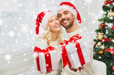 happy couple at home with christmas gift boxes