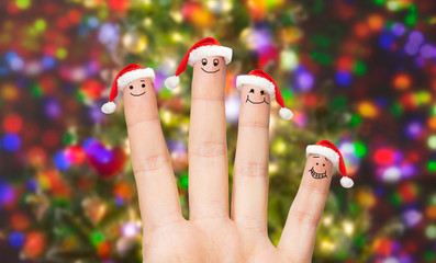 Naklejka premium close up of hand with four fingers in santa hats