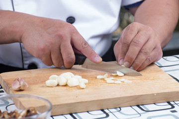 Obraz na płótnie Canvas Chef is cutting garlic 
