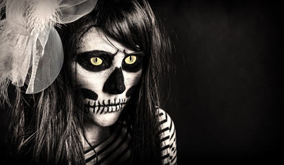 Young woman in day of the dead mask skull face art. Halloween.
