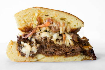 Smoked meat beef sandwich, with barbecue sauce and coleslaw isolated on a white background.