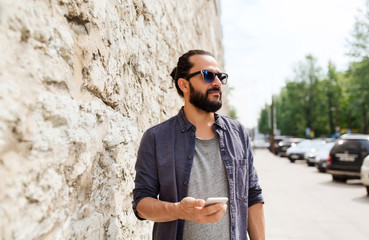 man with smartphone at stone wall