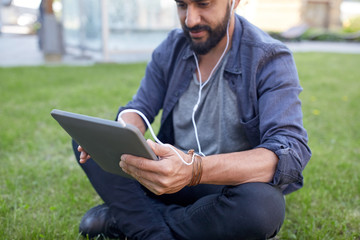 Obraz premium close up of man with tablet pc and earphones