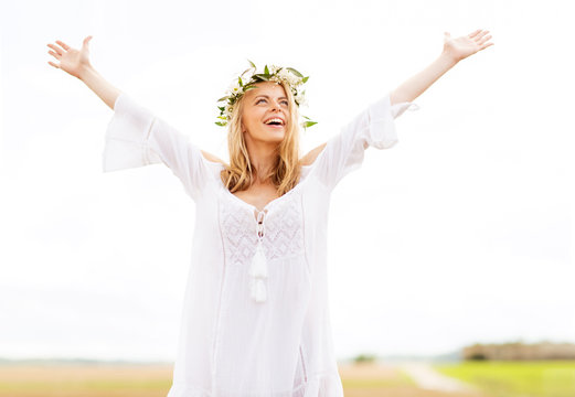 happy young woman in flower wreath on cereal field