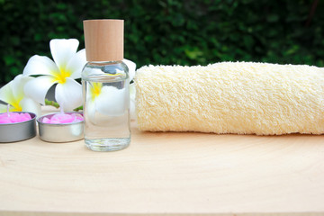 Spa still life with oil, towel, flower, aromatic candles on wooden table