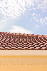 Roof tiles , rain gutter and windows against blue sky