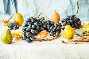 Fresh blue grapes and pears on a bright background