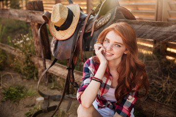 Close up portrait of a happy beautiful redhead cowgirl resting