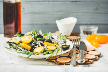 salad with arugula, yellow tomatoes, olives, grapes and sesame,