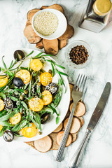 fresh green salad with arugula, yellow tomatoes, olives, grapes