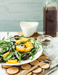 fresh green salad with arugula, yellow tomatoes, olives, grapes