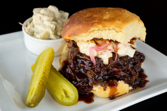 Smoked meat beef sandwich, with barbecue sauce, coleslaw served with potato mash and a pickle