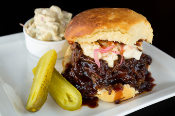 Smoked meat beef sandwich, with barbecue sauce, coleslaw served with potato mash and a pickle