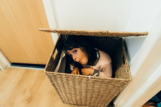 Young girl hiding in basket