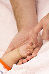 baby's hand and father's arms