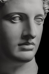 Gypsum statue of Apollo's head on a black background