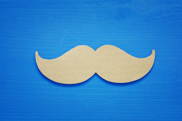 Blue wooden background and paper mustache