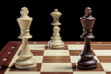 Chess queen and chess pawn in multiexposition and two chess kings nearby