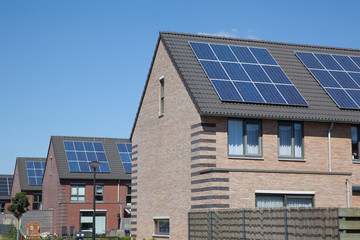 Fototapeta na wymiar Modern houses with solar panels on the roof for alternative ener
