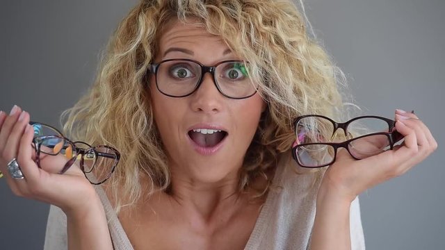 Blond woman with curly hair choosing between different eyeglasses