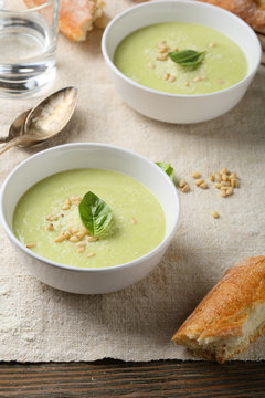 Green broccoli soup in white bowl