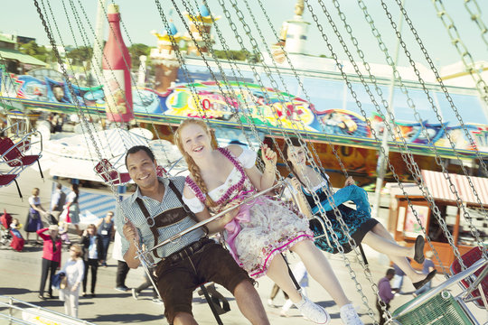 Couple having fun on chain carousel Ketten-Karussell at Oktoberfest