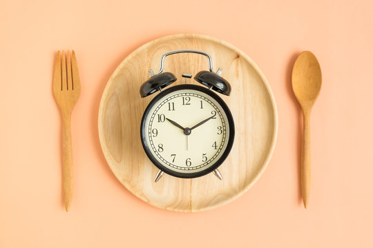 Top view of vintage clock on wooden plate