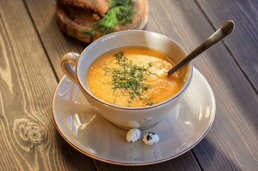 Pumpkin and lentil soup on dark wooden background. Halloween treat.