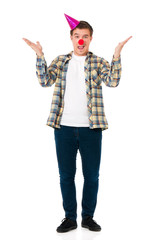 Handsome man clown isolated on white background. Teen boy with crazy look making faces and wearing red nose.