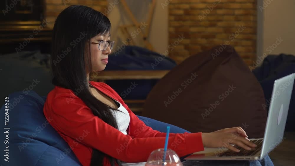 Poster young asian woman sitting in the cafe using laptop. beautiful girl typing on computer chatting in so