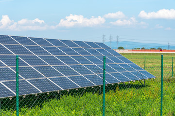 Solar panels in the field with blue sky. Photovoltaic modules produces green, environmentally...