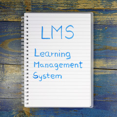 LMS- Learning Management System written in notebook on wooden background