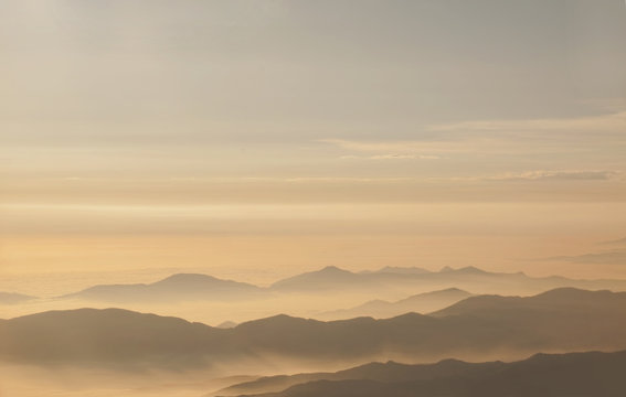 Cloudscape shot during golden hour with mountains in background