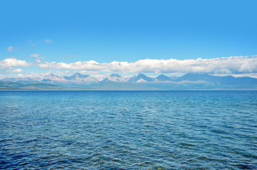 sea lanscape. blue sky, clouds over the surface of sea. mountain on horizon