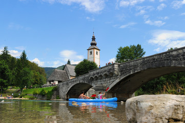Fototapeta na wymiar Church of St John the Baptist and stone bridge at Bohinj Lake, Slovenia