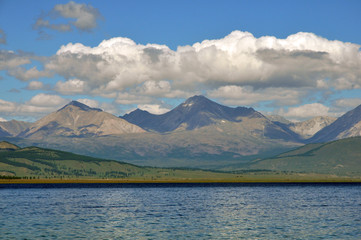 sea lanscape. blue sky, clouds over the surface of sea. mountain on horizon