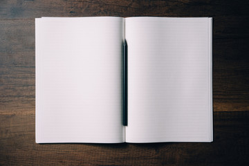 Overhead view of Blank Notebook with Black Pencil on Wood Table Background - Flat lay photography 