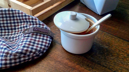 The Plaid Design cap and condiments on the table by the window.