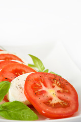 Caprese salad with mozzarella cheese, tomatoes and basil isolated on white background

