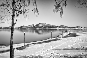Tranquil wintry scenery. Landscape, Black snowy mountain, clear sky on lake at a winter day, Greece