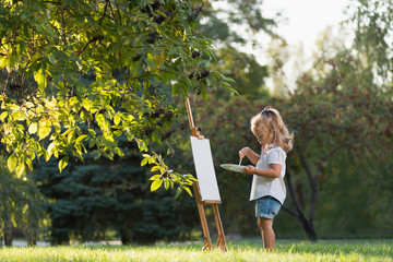 маленькая девочка рисует красками