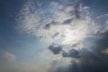 Fototapeta na wymiar Sun beam behind the clouds on blue sky