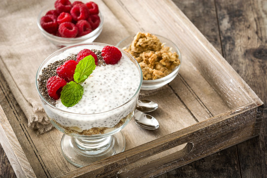 Chia yogurt with raspberries on wooden tray and wooden background


