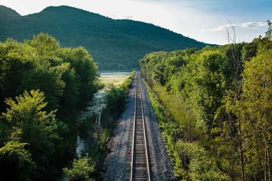 Railway track heading  towards green hills