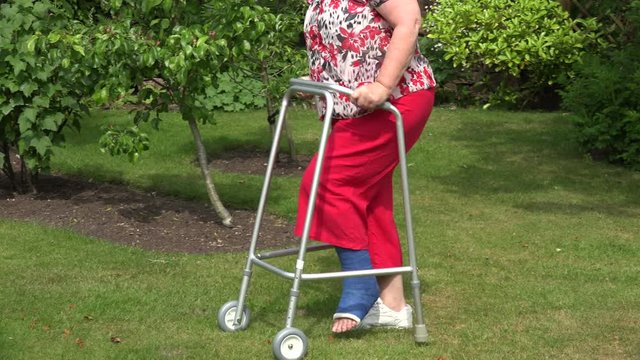 Woman with broken ankle walks with zimmer frame