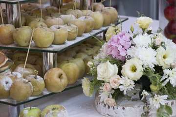 Baked apples in sweet syrup and powdered sugar near beautiaful bouqet