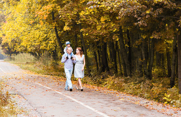 Fototapeta premium Happy family walking in autumn park