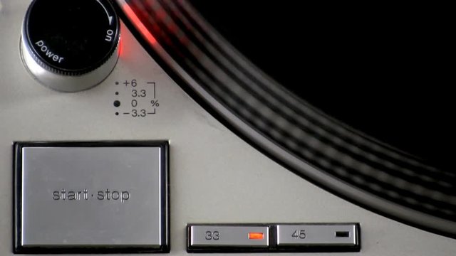 A close up of a turntable "start•stop",power and tempo controls.