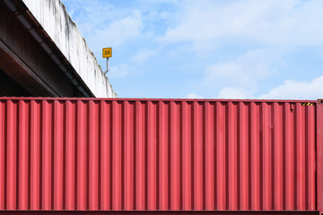 The red container storage under the road construction with the blue sky